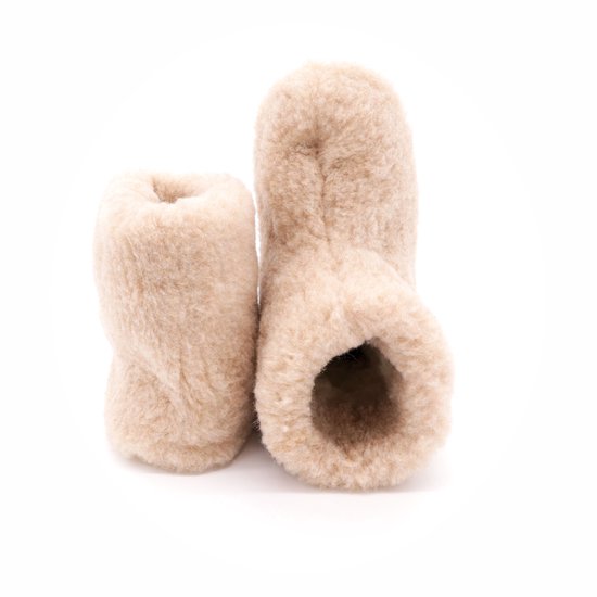 Hoge beige wollen sloffen met bruine zolen, van achteren gezien.