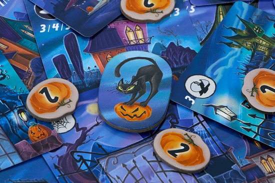 Zwarte kat op een pompoen, omringd door kaarten met griezelhuizen en spelonderdelen.