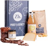 Een cadeaupakket met kaas, worst, worstbroodjes, appelsap, chips en noten.