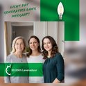 Drie vrouwen glimlachen naar de camera. Een kaarslamp is zichtbaar. Tekst: Licht dat generaties lang meegaat!