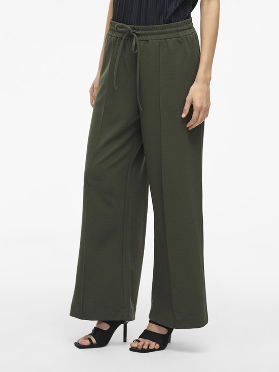 Close-up van een wijde donkergroene broek met hoge taille en koord.