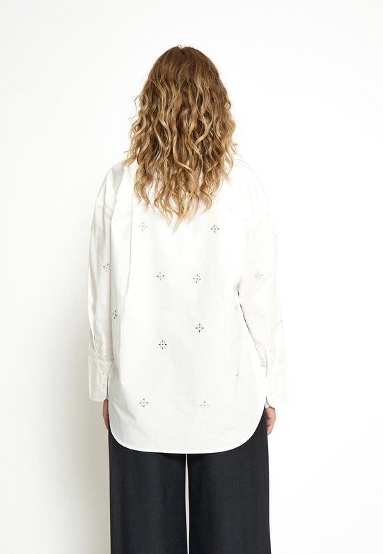 Achterkant van een wit katoenen oversized blouse met knoopsluiting en subtiele glitterapplicaties.