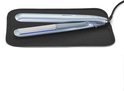 Een lichtblauwe BaByliss stijltang met geopende platen, liggend op een zwarte hittebestendige mat.