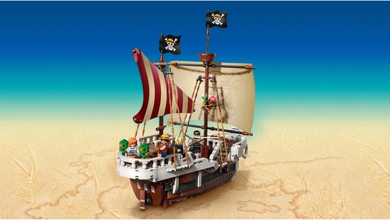 LEGO One Piece Piratenschip Going Merry op zandige achtergrond, met strooien hoeden en schedel logo op zeil.