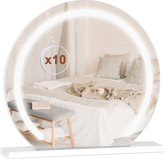 Ronde make-upspiegel met LED-verlichting en een 10x vergrotingsspiegel, reflecteert een bed met kussens en een dienblad met kopje.
