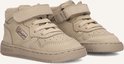 Close-up van twee taupe suède mid-top sneakers met klittenbandsluiting en veters.