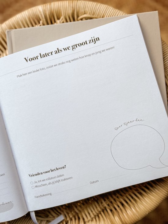 Openstaand vriendenboek met de tekst 'Voor later als we groot zijn' en ruimte voor een foto. Ligt op een rieten stoel.