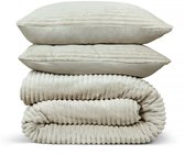Gestapelde licht beige ribbed flanellen kussenslopen en dekbed.