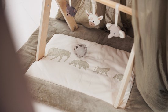Houten babygym met beige speelmat met dierenprint, met hangende knuffels van een giraffe, beer en olifant.