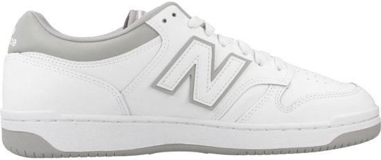 Witte lage sneaker van New Balance met grijze accenten en een groot grijs 'N' logo op de zijkant.