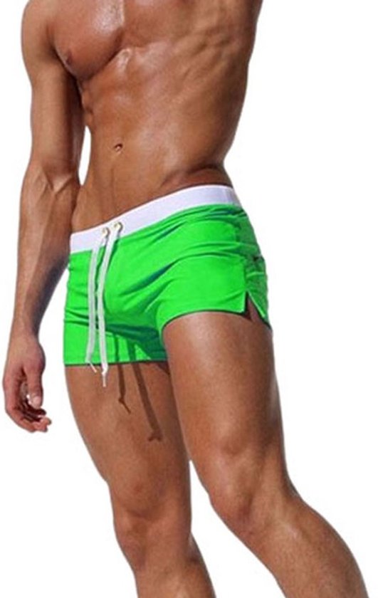 Un mannequin porte un maillot de bain vert avec ceinture blanche et cordon de serrage.