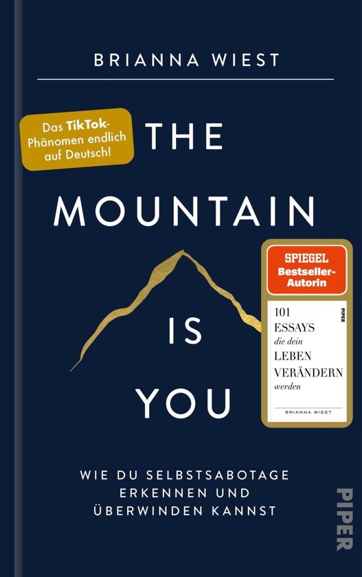 Couverture du livre 'The Mountain Is You' avec des montagnes dorées et du texte en blanc, jaune et noir. Avec "Das TikTok-Phänomen endlich auf Deutsch!".
