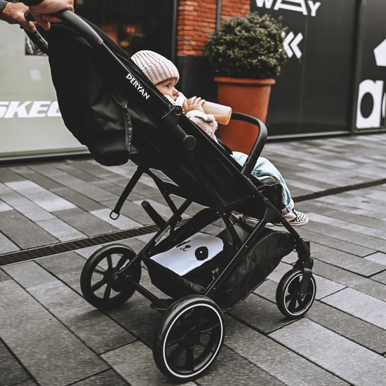 Gezichtspunt vanuit de buggy op een baby met muts en jasje, met de Deryan-logo op de zijkant.