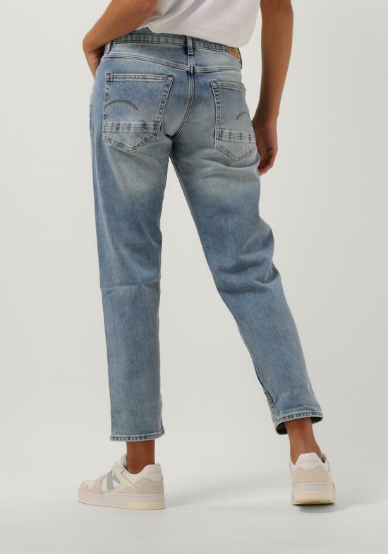 Achterkant van model in lichtblauwe G-Star Raw jeans met opgerolde pijpen.