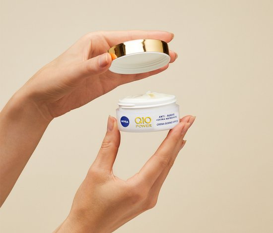 Nivea Q10 Power dagcrème potje met deksel in de hand, met tekst 'Q10 POWER ANTI-RUGHE EXTRA NUTRIENTE CREMA GIORNO SPF 15'