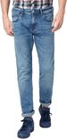 Man in een blauwe jeans met opgerolde broekspijpen, gedragen met een geruit shirt en blauwe sneakers.