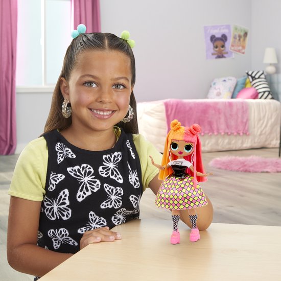 Kind met grote oorbellen naast een fashiondoll met tweekleurig oranje-roze haar en een ruitjesrok.