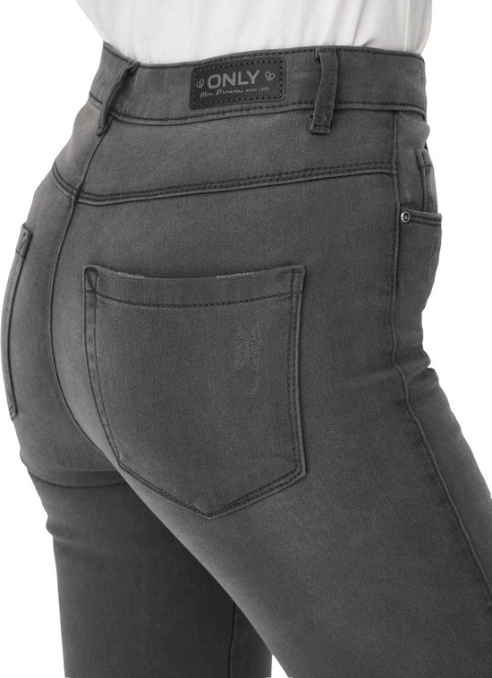 Achterkant van een grijze skinny jeans met merklogo op de tailleband.