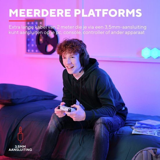 Jonge man met zwarte gaming headset, zittend op bed, spelend met controller.