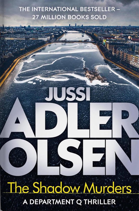 Boekomslag van 'The Shadow Murders' door Jussi Adler Olsen. Een ijskoude stad met een deels bevroren rivier op de voorgrond. Internationaal bestseller.
