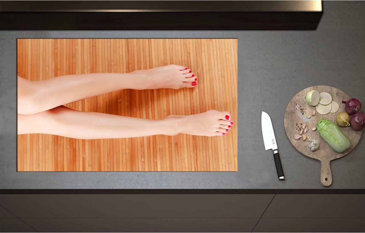 Inductieplaat Beschermer - Bovenaanzicht van Vrouwen Benen met Roodkleurige Teennagels op Houten Ondergrond - 90x55 cm - 2 mm Dik - Inductie Beschermer - Bescherming Inductiekookplaat - Kookplaat Beschermer van Zwart Vinyl