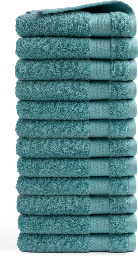 Une pile de douze serviettes bleu clair avec un motif détaillé sur les bords, sur fond blanc.
