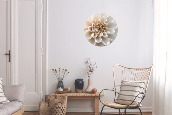 Wandcirkel met witte dahlia met beige midden, in een lichte woonkamer.