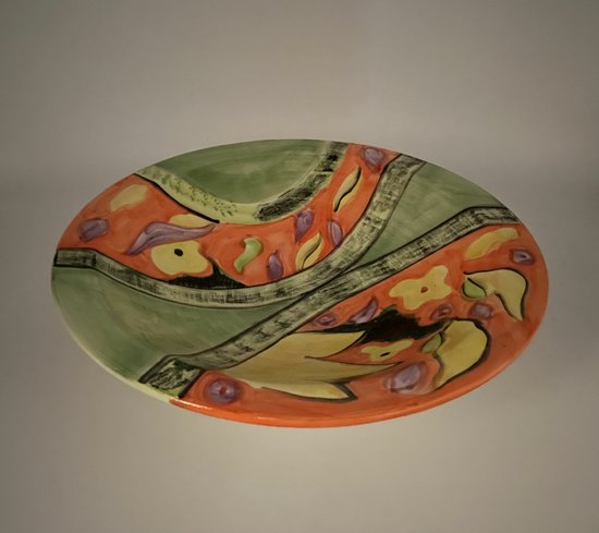 Plat de service ovale avec des motifs verts, oranges et jaunes et des détails lilas.
