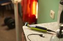 Gele en zwarte Philips OneBlade trimmer op een marmeren tafel, met een USB-kabel aangesloten.