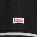 Detail van een witte badge met rood en blauw Lonsdale London logo op een zwarte Lonsdale polo.