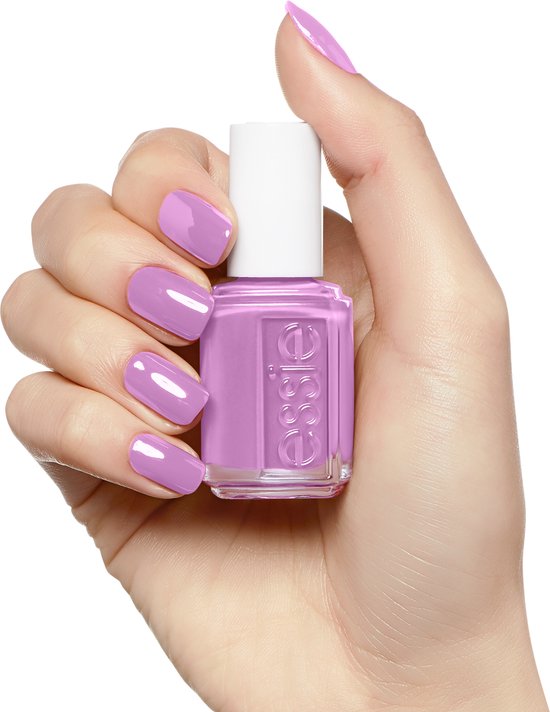 Hand met nagels gelakt in zacht paars, met Essie nagellakflesje.