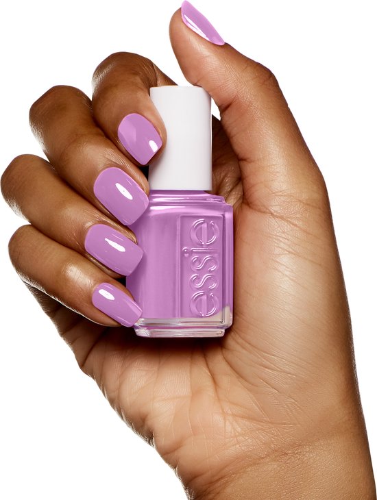 Hand met nagels gelakt in zacht lavendelpaars, met Essie nagellakflesje.