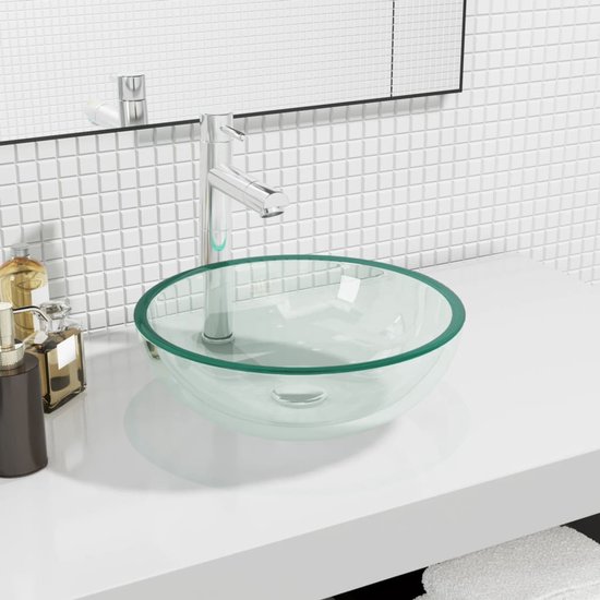 Lavabo en verre teinté vert clair sur un plan de travail blanc avec un robinet argenté.
