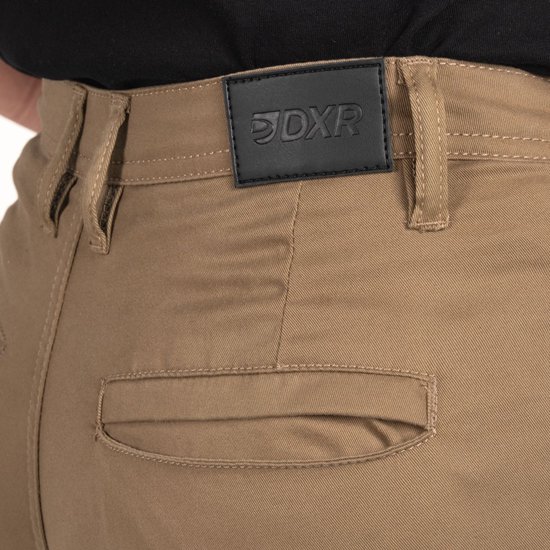 Achterkant van een beige motorbroek met zwart leren label met logo DXR.