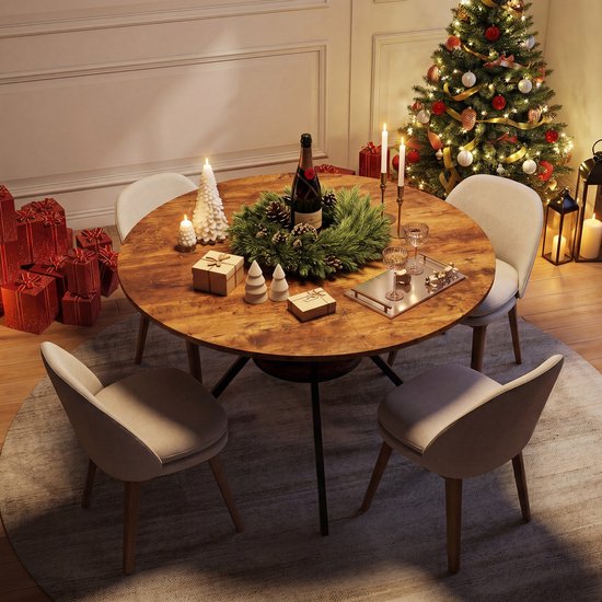 Ronde eettafel in kerstsfeer, gedekt met servies en versierd met een kerstkrans. Omringd door stoelen, met kerstcadeaus en een kerstboom op de achtergrond.