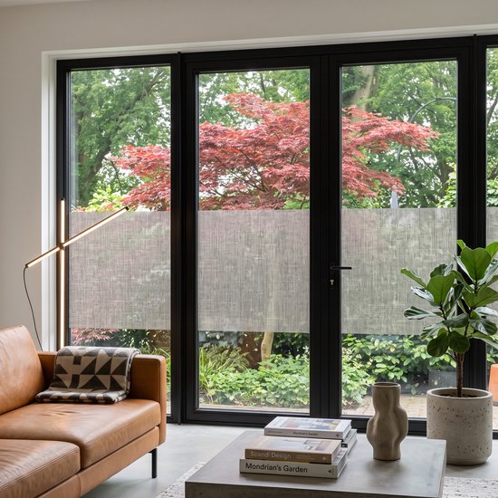 Woonkamer met grote glazen deuren met raamfolie met textielstructuur.