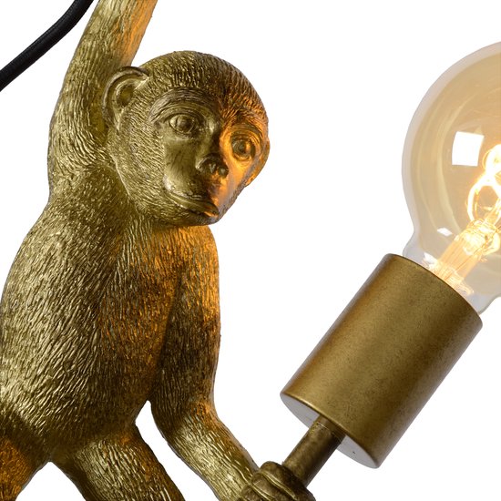 Close-up van een gouden wandlamp, een aap figuur met een gloeilamp.
