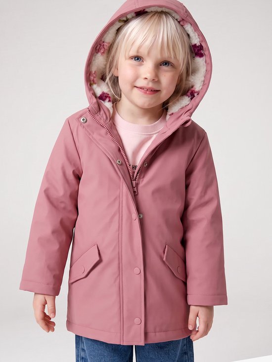 Meisje met blond haar, lachend, met roze regenjas met bloemenprint op de teddy voering van de capuchon, en spijkerbroek.