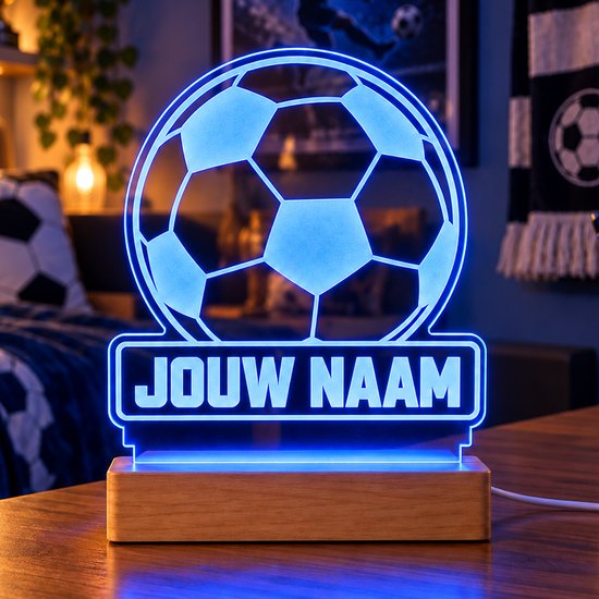 Gepersonaliseerde voetbal LED-lamp met blauw licht en tekst 'JOUW NAAM' op een houten voet.