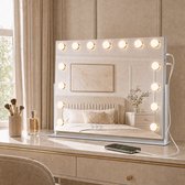Witte Hollywood-spiegel op een kaptafel met smartphone verbonden via USB-kabel voor opladen.