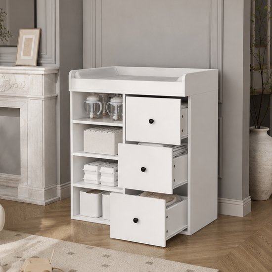 Witte commode met open legplanken en lades in een lichte kamer met openstaande schuifladen.