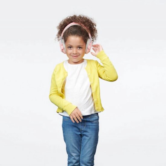 Kind met krullend haar draagt roze Alpine gehoorkappen, een geel vest en een witte top.