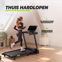 Vrouw in sportkleding rent thuis op de zwarte VirtuFit TR100i loopband in een licht interieur.