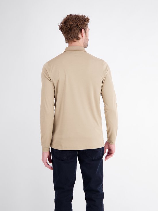 Achterkant van een man in beige poloshirt met lange mouwen en donkerblauwe broek.