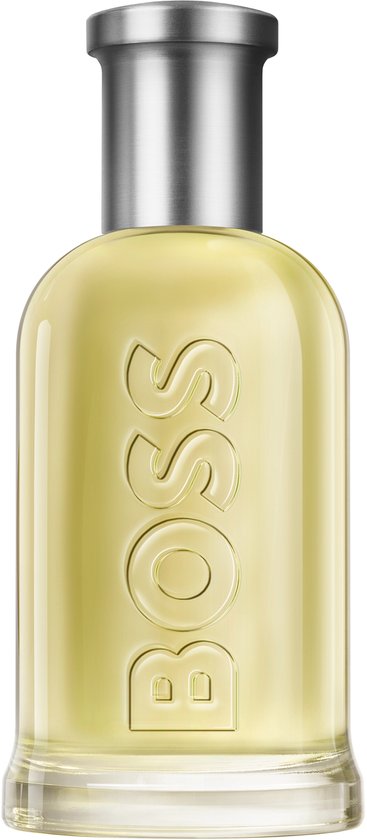 Een glazen parfumfles met een zilveren dop, gevuld met gele eau de toilette, met het woord "BOSS" in reliëf.