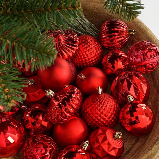 Close-up van rode, onbreekbare kerstballen met diverse structuren en afwerkingen.