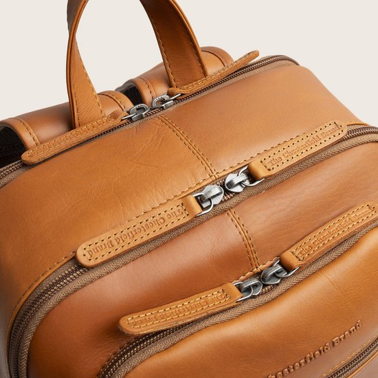 Bovenaanzicht van een bruine leren rugzak met meerdere ritsen en The Chesterfield Brand branding.