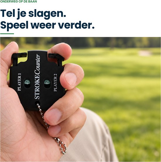 Hand die zwarte Stroke Counter vasthoudt op een golfbaan, toont scores voor twee spelers.