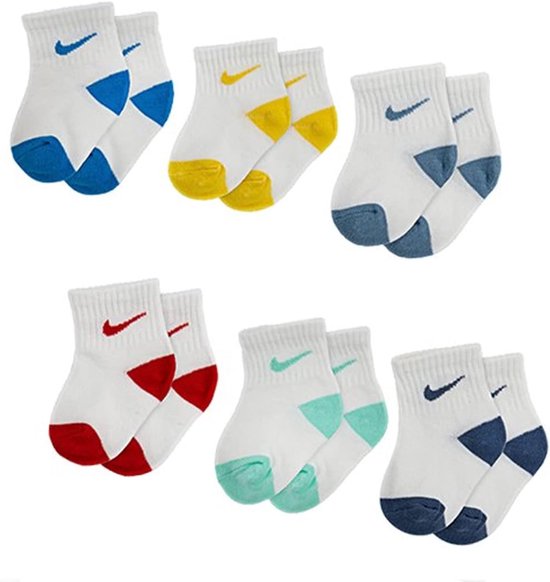 Zes paar witte Nike enkelsokken voor kinderen met diverse gekleurde accenten bij de hiel, teen en Swoosh.