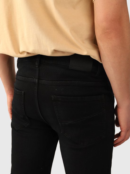 Detail van de achterzakken van zwarte denim shorts met een Brunotti-label op de tailleband.
